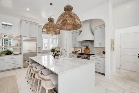 a kitchen with stainless steel appliances a sink a stove and a chandelier