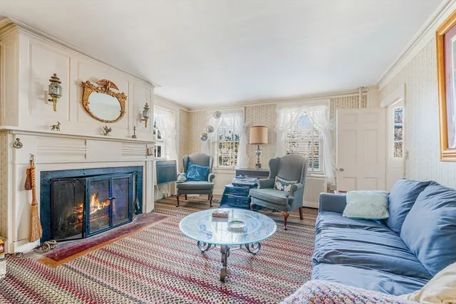 a living room with furniture a clock and a fireplace