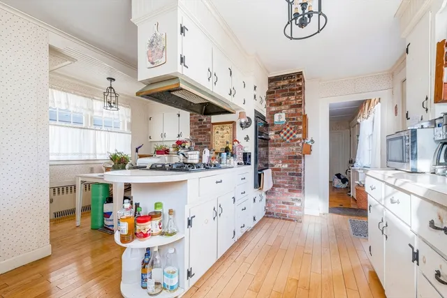 a kitchen with stainless steel appliances granite countertop a lot of cabinets and wooden floor