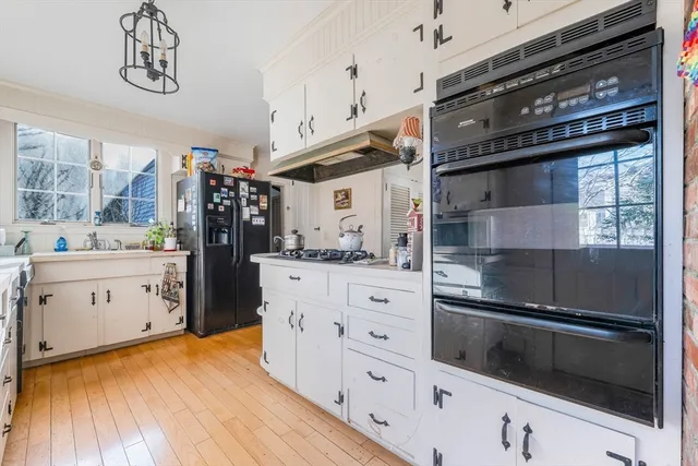 a kitchen with a refrigerator and white cabinets