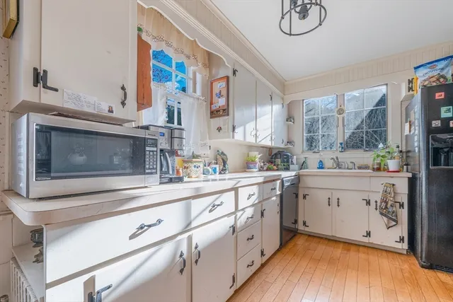 a kitchen with granite countertop white cabinets and white appliances