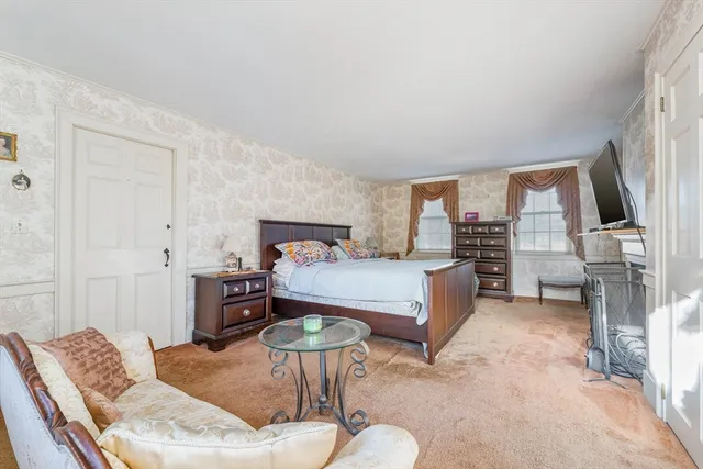 a bedroom with a bed and a dresser with wooden floor