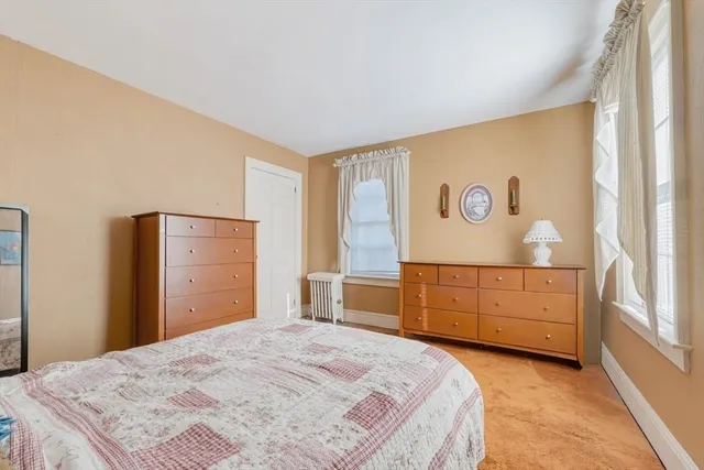 a view of a bedroom with furniture and window