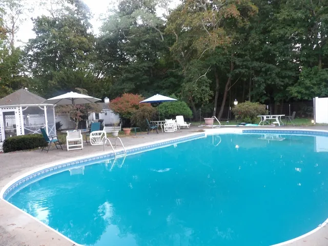a swimming pool with outdoor seating and yard