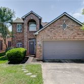 a front view of a house with a garden and plants