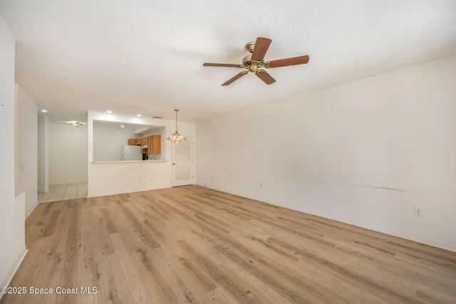 a view of a livingroom with a hardwood floor and a ceiling fan