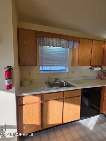 a kitchen with granite countertop white cabinets sink and window