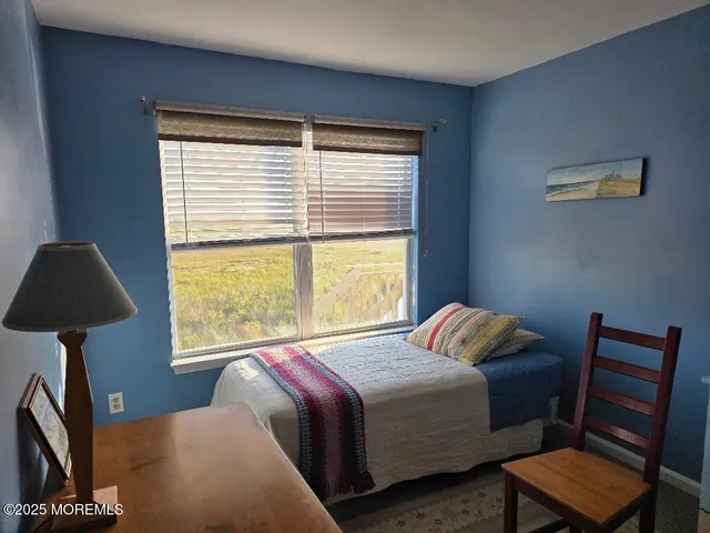 a bedroom with a bed and a lamp next to a window