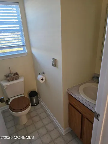 a bathroom with a granite countertop toilet and a sink
