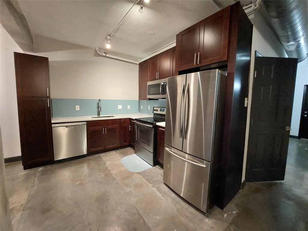 a kitchen with stainless steel appliances wooden cabinets and a refrigerator