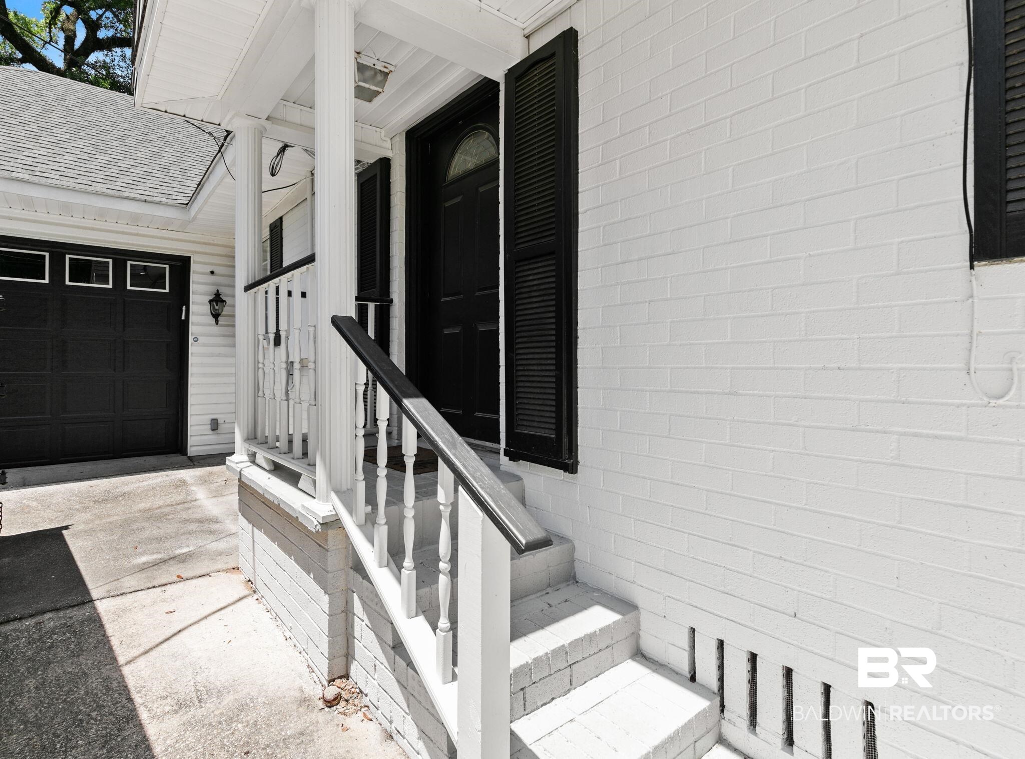 927 Cleveland Road Saraland, AL 36571 - Photo 50 of 80 Front entry featuring a white brick facade, covered porch, and white baluster railing