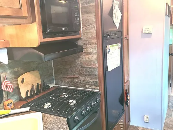 a room with stainless steel appliances wooden floor and utility
