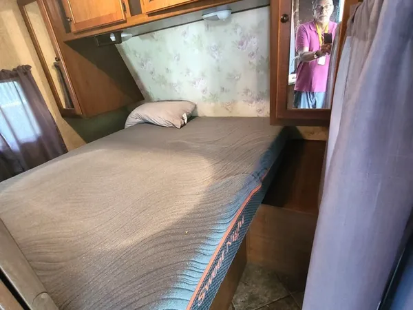 a bedroom with a bed and a mirror