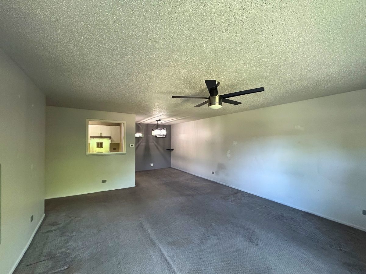 1206 New Wilke Road, Unit 206 Arlington Heights, IL 60005 - Photo 5 of 17 an empty room with a ceiling fan and a window