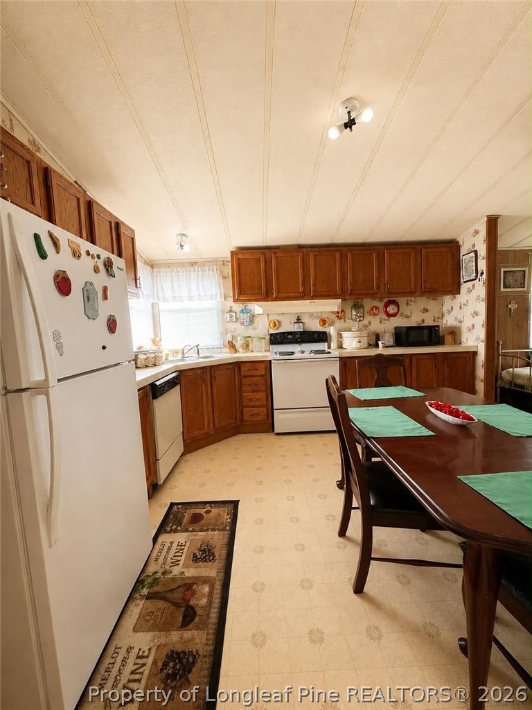 4435 Tartt's Mill Road Wilson, NC 27893 - Photo 8 of 23 a kitchen with a refrigerator a stove a sink and a dining table