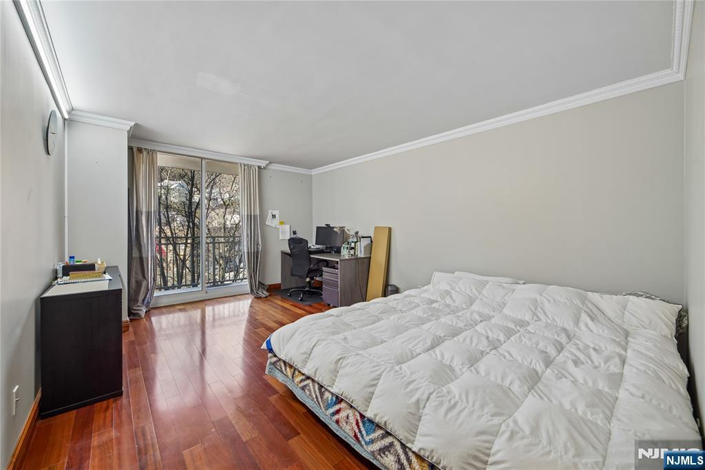 1055 River Road, Unit 302 Edgewater, NJ 07020 - Photo 8 of 17 a bed sitting in a bedroom next to a window