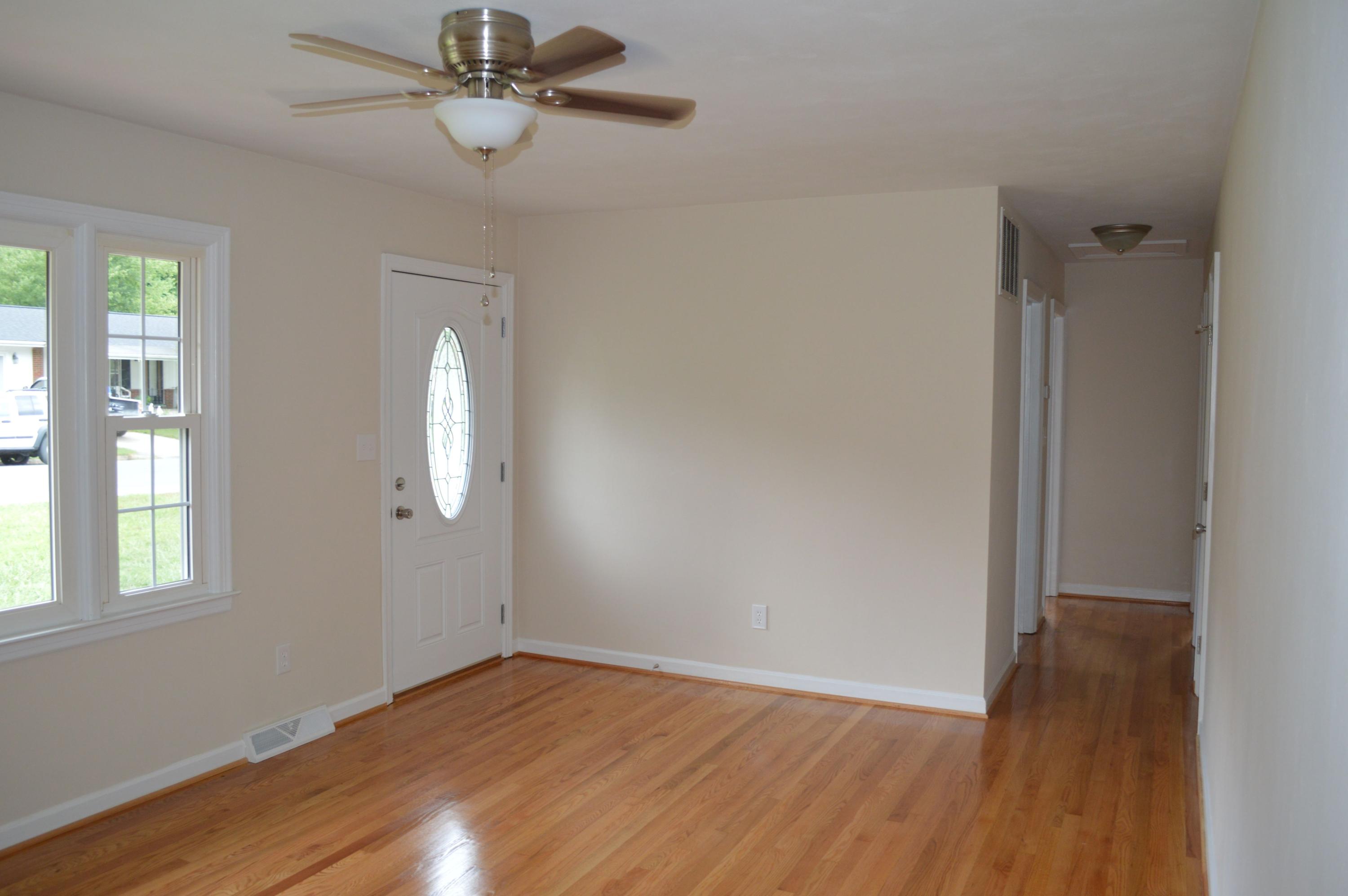 520 Olney Road Vinton, VA 24179 - Photo 3 of 29 an empty room with wooden floor fan and windows