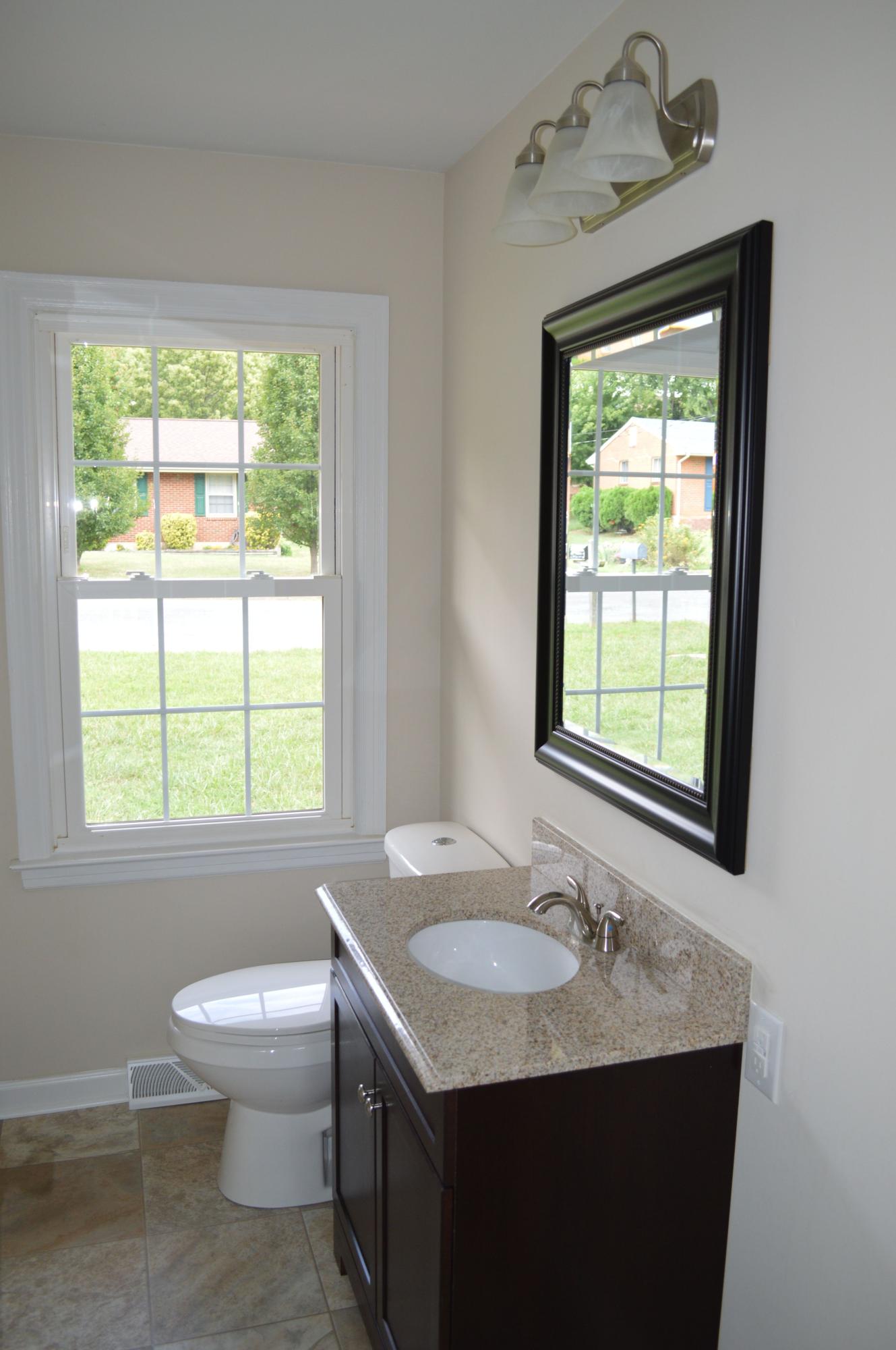 520 Olney Road Vinton, VA 24179 - Photo 10 of 29 a bathroom with a granite countertop sink toilet and next to a window