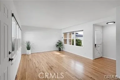 a view of a room with wooden floor and window
