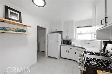 a kitchen with white cabinets and white appliances