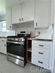 a kitchen with granite countertop white cabinets and stainless steel appliances