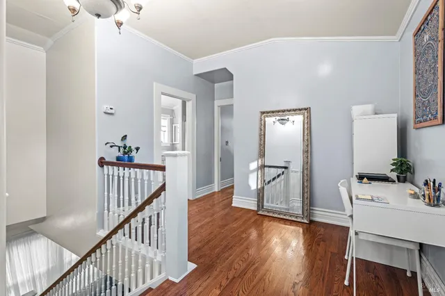 a view of a hallway with wooden floor windows a chandelier and entryway