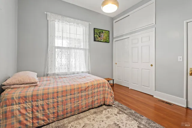a bedroom with a bed and wooden floor