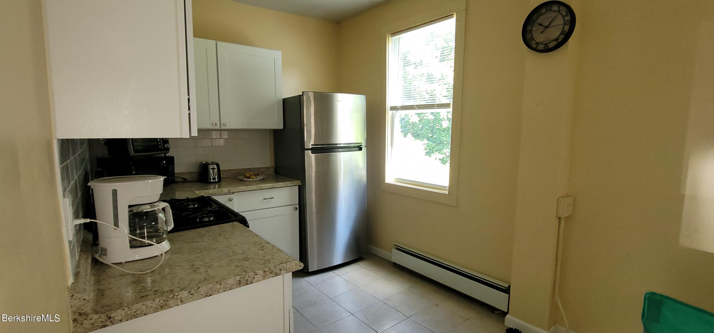 18 Grove Avenue Adams, MA 01220 - Photo 3 of 10 a kitchen with a refrigerator and a stove top oven