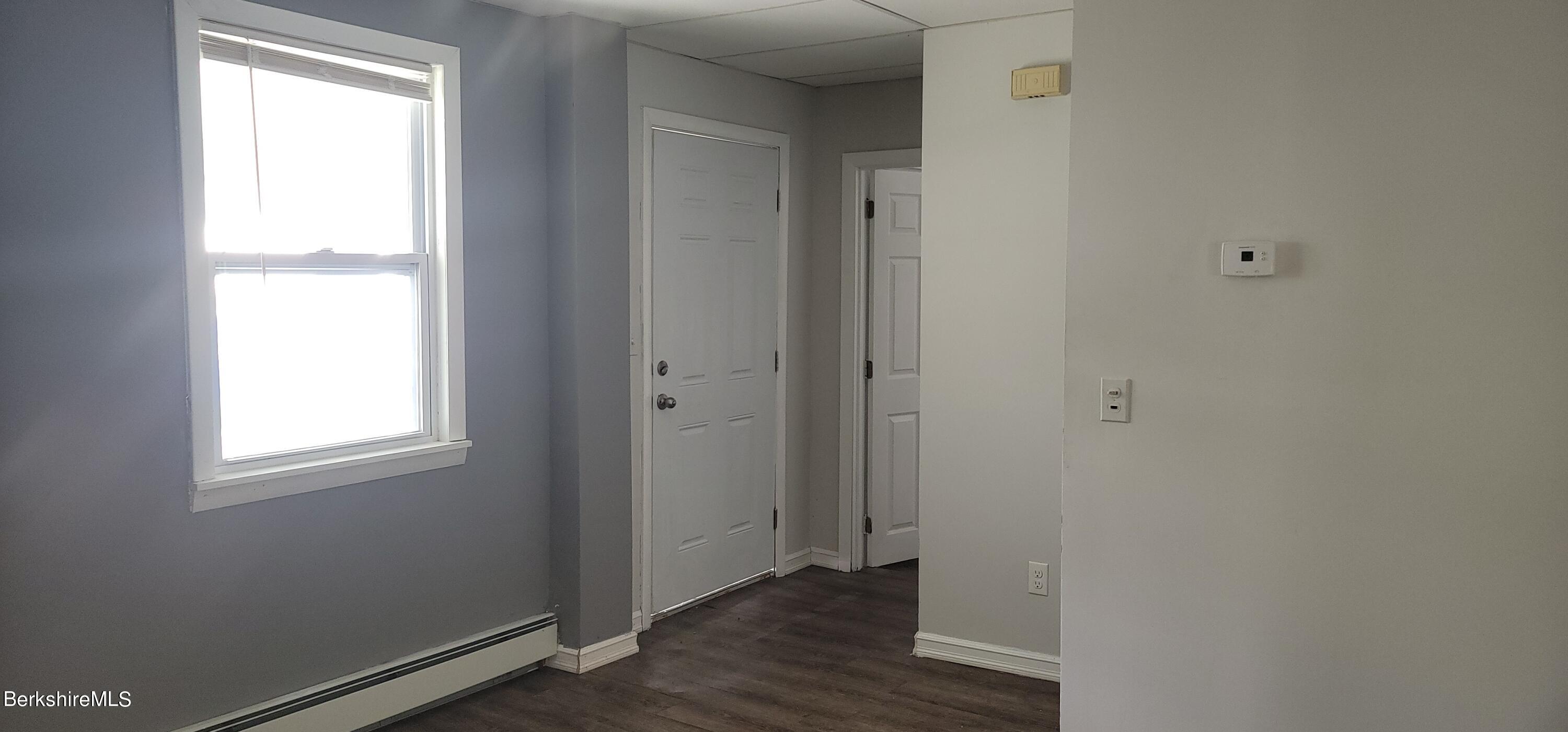 18 Grove Avenue Adams, MA 01220 - Photo 4 of 10 an empty room with wooden floor and windows