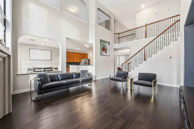 a living room with furniture and a dining table with wooden floor