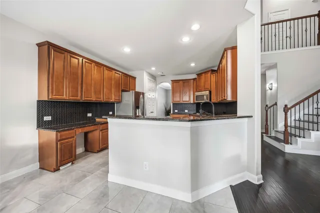 a open kitchen with stainless steel appliances granite countertop a refrigerator stove top oven and large window