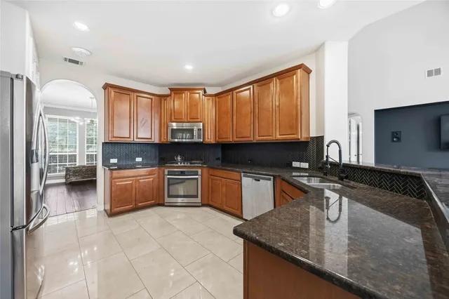 a kitchen with stainless steel appliances granite countertop a stove a sink and a granite counter tops