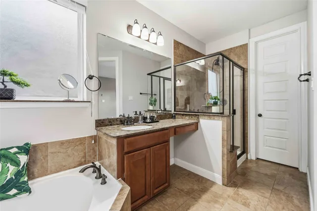 a bathroom with a sink vanity granite tub and shower