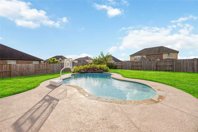 a view of a fountain in front of a house with a yard