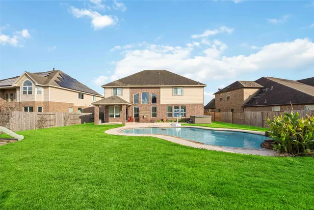 a view of a house with a big yard and a fountain