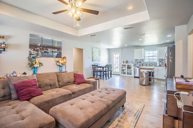 a living room with furniture and view of kitchen