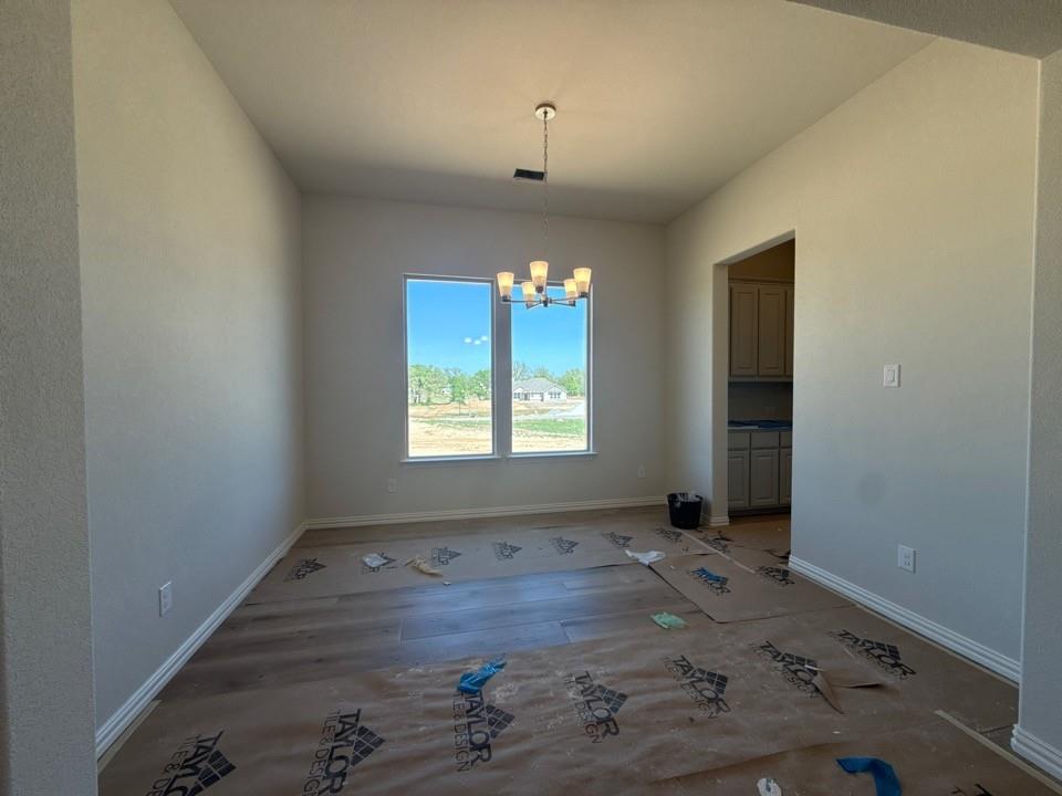 605 Tay Tay Way Springtown, TX 76082 - Photo 7 of 19 an empty room with wooden floor and windows