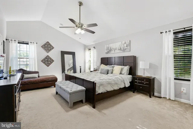 a spacious bedroom with a bed a couch and a window