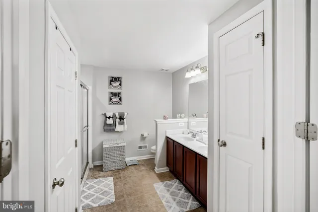 a spacious bathroom with a double vanity sink and a mirror