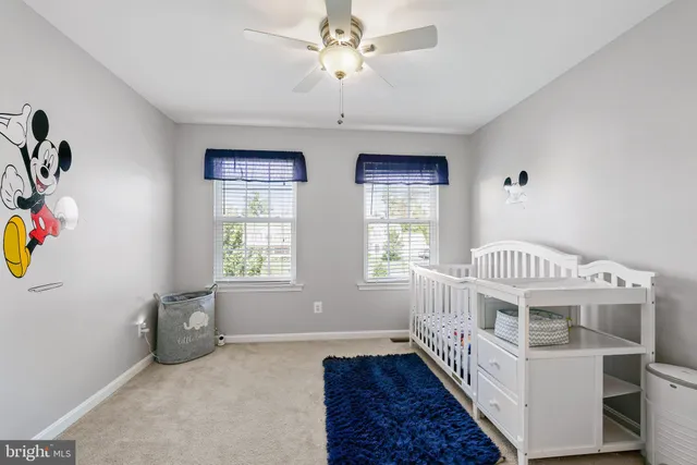 a view of an bedroom with window and ceiling fan