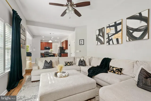a living room with furniture and a view of kitchen