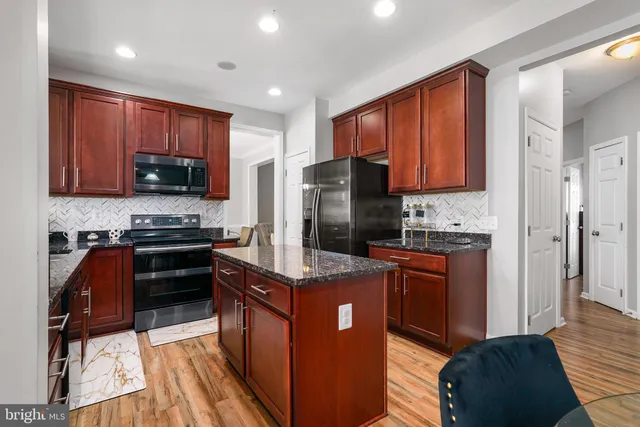 a kitchen with stainless steel appliances granite countertop a stove refrigerator sink and microwave