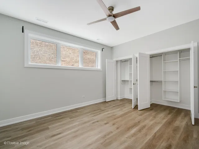 a view of empty room with wooden floor and window