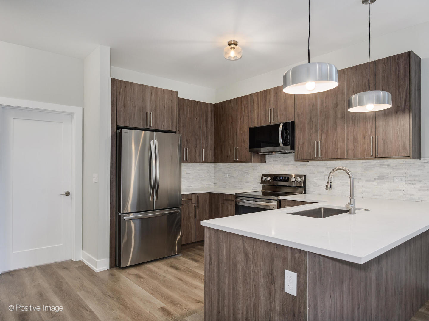 3944 South Indiana Avenue, Unit 1F Chicago, IL 60653 - Photo 2 of 12 a kitchen with stainless steel appliances a refrigerator a sink a center island and wooden floor