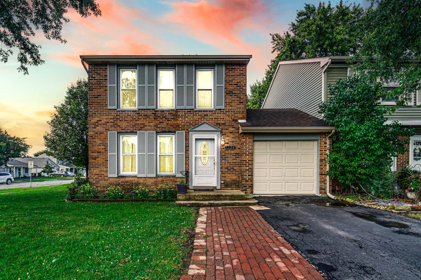 a front view of a house with a yard and trees