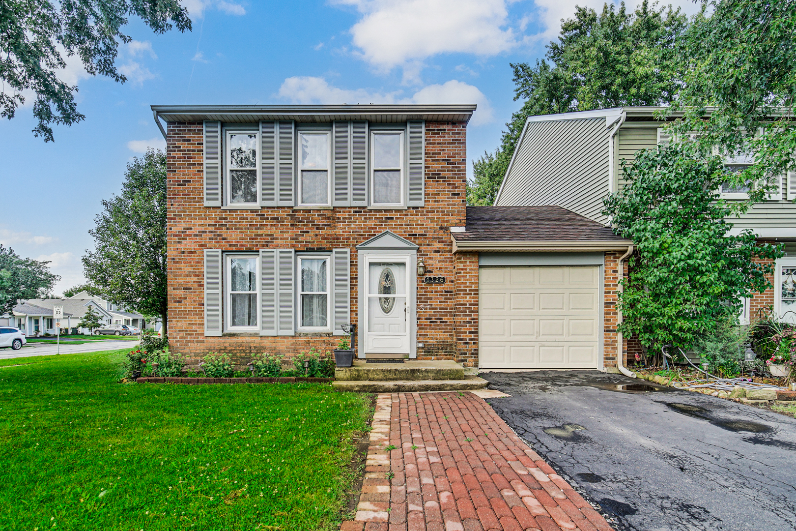 1326 Spring Valley Drive, Unit 1326 Carol Stream, IL 60188 - Photo 2 of 18 a front view of a house with a yard and garage