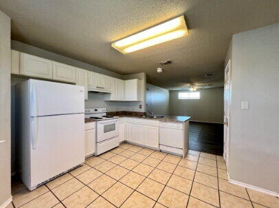 5845 7th Street, Unit B Lubbock, TX 79416 - Photo 3 of 11 a kitchen with a cabinets and white appliances
