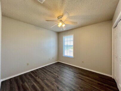 5845 7th Street, Unit B Lubbock, TX 79416 - Photo 9 of 11 wooden floor in an empty room with a window