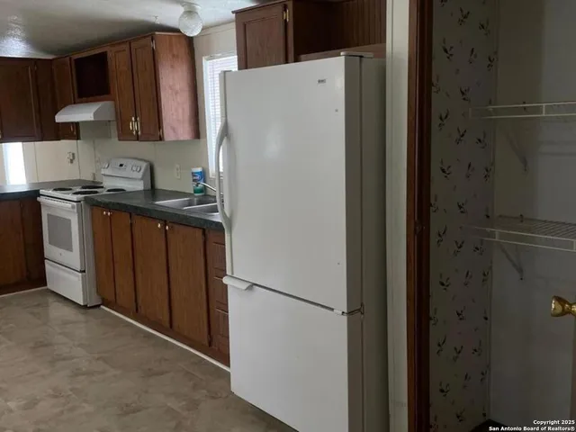 a kitchen with granite countertop a stove a sink and a microwave