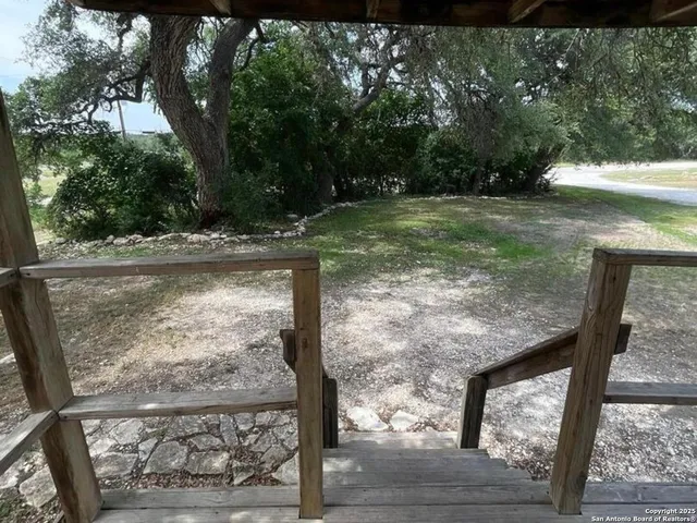 a view of a backyard with wooden floor and fence